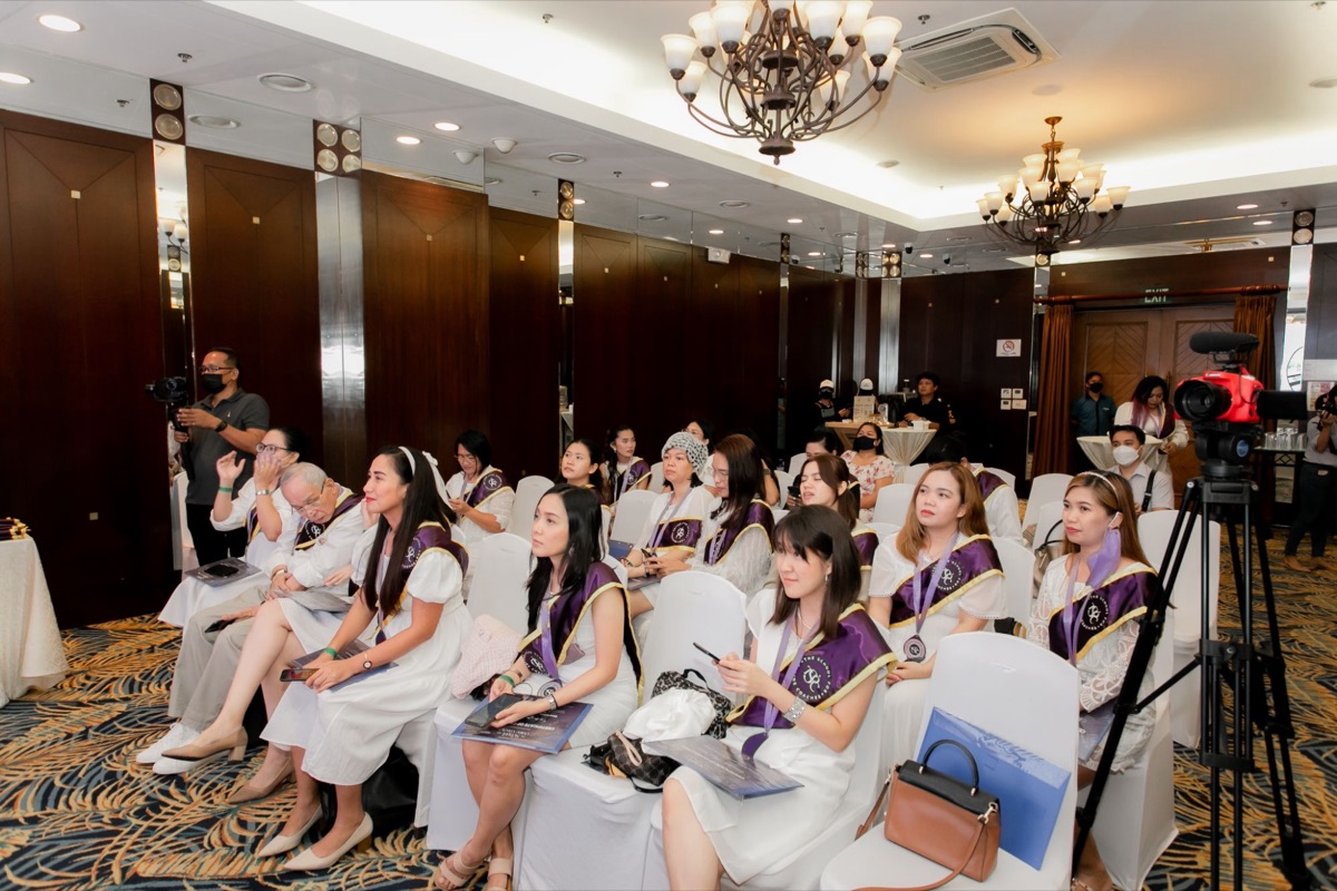 Graduates in their sashes listening during the ceremony